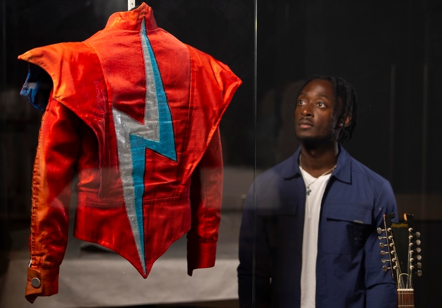 A visitor looks at the Aladdin Sane jacket designed by Freddie Burretti for David Bowie on the Ziggy Stardust live tour in 1973 on display in the David Bowie Centre